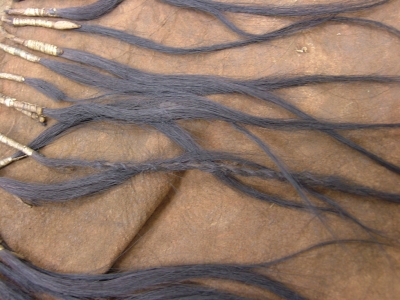 1893.67.4 - a close-up of twisted locks of hair which are used to fringe the garment