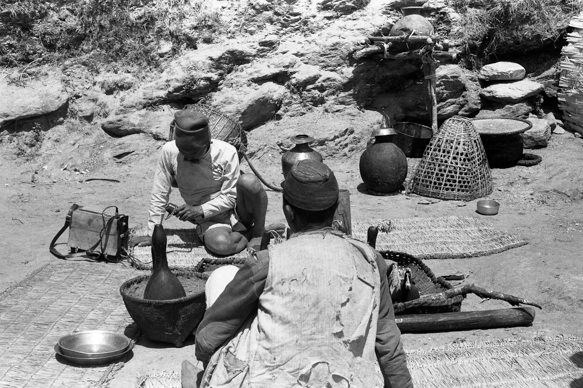 Dan Bahadur examining the ethnographer's tape recorder. Gourds (Thul bom) are very characteristic of Thulung rituals. (East Nepal, 31st March 1970) [2008.115.201]