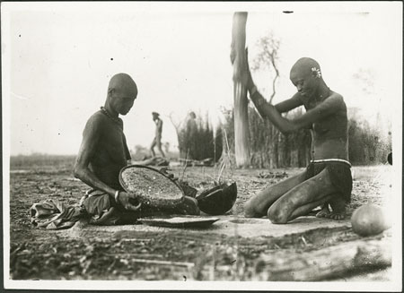 Nuer women preparing grain