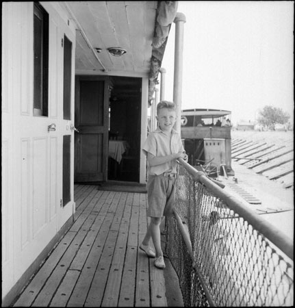 European boy on boat deck