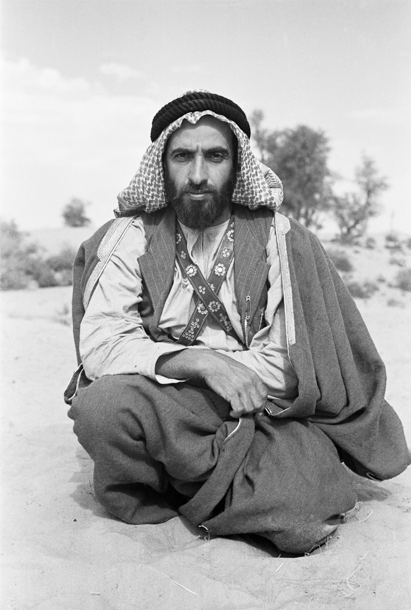Seated portrait of Sheikh Zayed bin Sultan Al Nahyan resting in the sand in Al Ain.