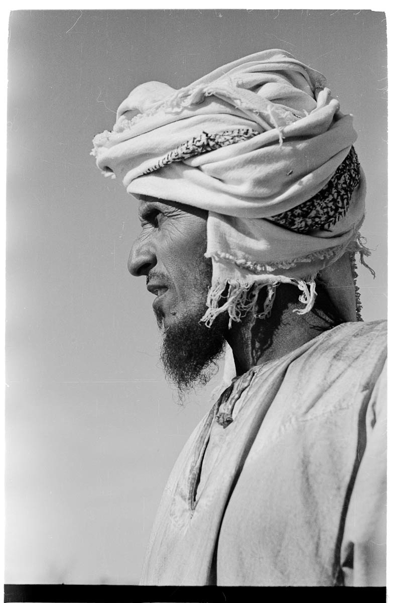 Close up profile portrait of Huaishil, one of Wilfred Thesiger's travelling companions, in the region surrounding Al Ain / Buraimi Oasis.