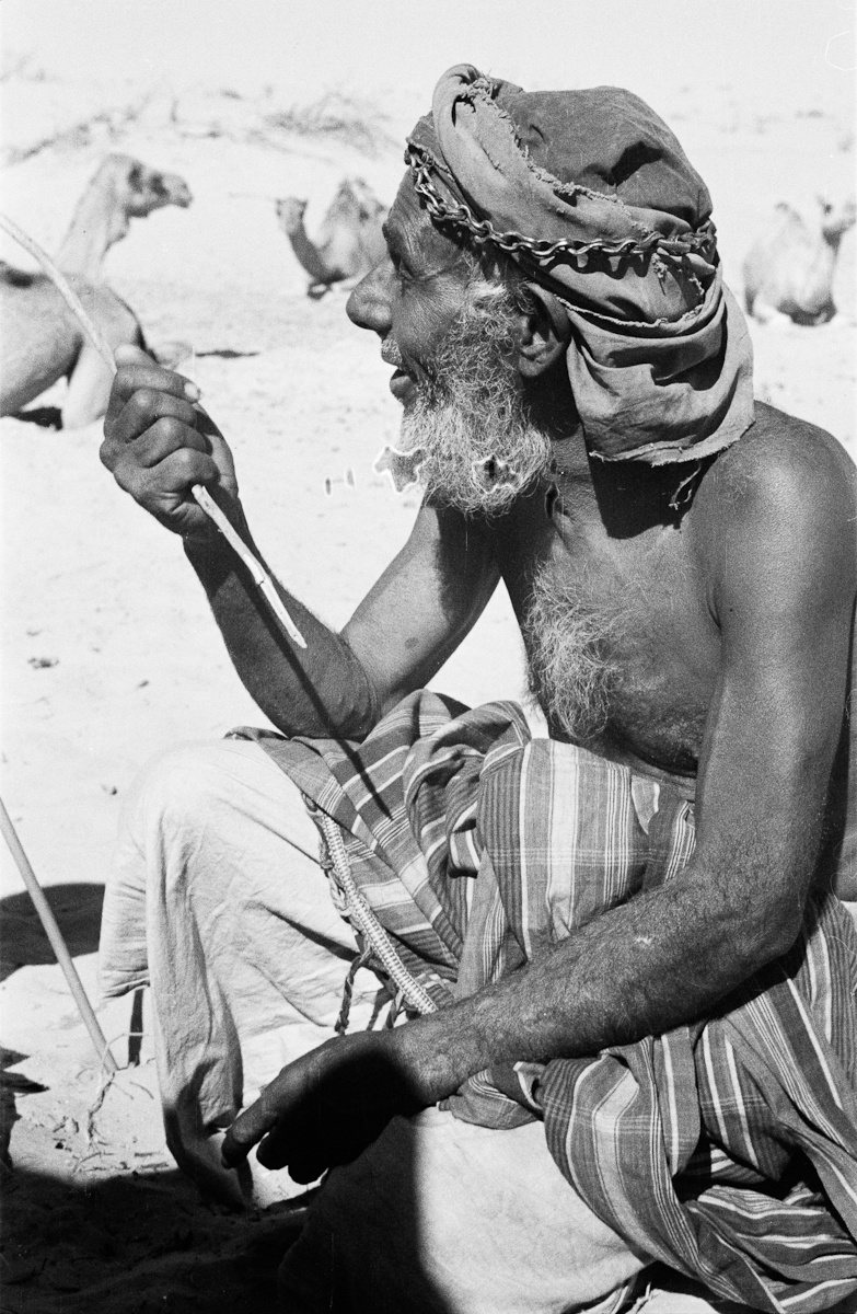 Portrait of Salim bin Tamtaim, one of the leaders of Wilfred Thesiger's travelling party, at a well in the Ghanim Sands during the party's journey from Khasfah well to Matki well.