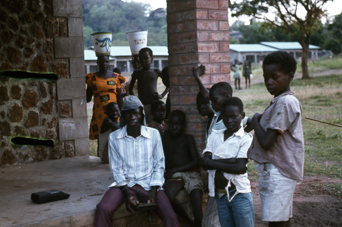 Boys and girls listening to Timon Beri playing sanza (Lui village school, Eastern Equatoria, Moru Misa, Jan-Feb 1979)